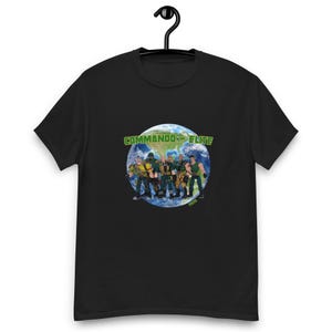 May include: Black t-shirt with a green graphic of a group of cartoon characters standing on a globe. The text "Commando Elite" is above the globe.