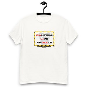 May include: White t-shirt with a yellow and black caution sign that says "CAUTION: LIVE ANIMALS" with a gray gorilla face inside the sign. The text "SECURITY ACCESS ONLY" is below the sign.