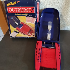 Könnte beinhalten: Ein blaues und rotes Spiel namens "Outburst!" Das Spiel ist ein schnelles Wortspiel, bei dem die Spieler Wörter erraten müssen, die von ihren Teamkollegen gegeben werden. Das Spiel beinhaltet einen Timer, einen Kartenhalter und einen Satz Karten mit Wörtern darauf. Das Spiel ist für 2 oder mehr Spieler und wird für Spieler ab 12 Jahren empfohlen.