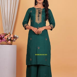 May include: A green kurta and palazzo set with gold embroidery. The kurta has a round neckline and three-quarter sleeves. The palazzo pants have a wide leg and a gold border.
