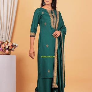 May include: A teal green kurta with gold embroidery and a matching palazzo pant. The kurta has a tie-up neckline and the palazzo pant has a gold border. The outfit is paired with a matching teal green dupatta with gold embroidery.