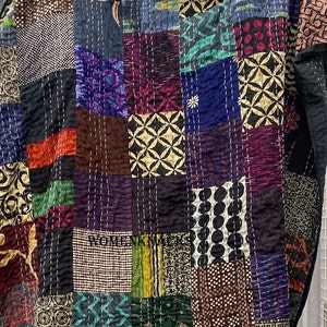 May include: A patchwork quilt with a variety of colorful fabrics and patterns. The quilt is made of squares and rectangles, and the seams are visible. The quilt is made of a variety of fabrics, including cotton, silk, and velvet. The quilt is a beautiful example of handmade craftsmanship.