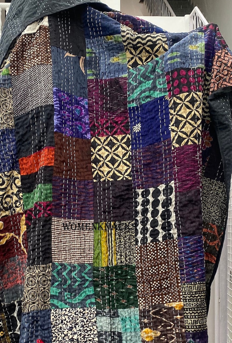 May include: A patchwork quilt with a variety of colorful fabrics and patterns. The quilt is made of squares and rectangles, and the seams are visible. The quilt is made of a variety of fabrics, including cotton, silk, and velvet. The quilt is a beautiful example of handmade craftsmanship.
