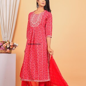 May include: A red printed kurta with a matching red palazzo pant and a red dupatta. The kurta has a floral print and a white embroidered neckline. The dupatta has a small geometric print.