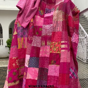 Pu&ograve; includere: Una trapunta patchwork composta da quadrati di tessuto in varie tonalit&agrave; di rosa e magenta con cuciture kantha bianche. Il tessuto presenta diversi motivi, tra cui disegni floreali, geometrici e astratti, con il testo WOMEN KNACKS.
