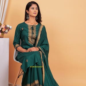 May include: A green kurta with gold embroidery and a matching dupatta. The kurta has a tie-up neckline and three-quarter sleeves. The dupatta has a gold border.