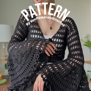 May include: A black long-sleeved crochet top featuring a deep V-neckline and wide, flared bell sleeves with a ruffled edge. The garment has an open, airy stitch pattern throughout. The text "PATTERN By sunflowerandcrochet" is overlaid on the image.