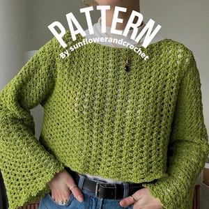 以下が含まれることがあります： 長袖とテクスチャード加工のオープン織りデザインが特徴のライムグリーンのクロシェ編みセーター。「PATTERN」の文字が「by sunflowerandcrochet」とともに白文字で表示されています。セーターはブルージーンズと黒いベルトと組み合わせています。
