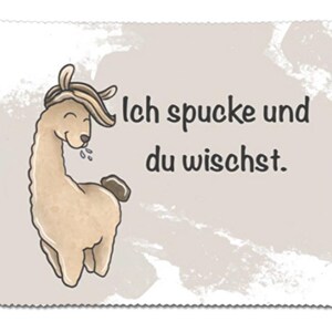 Op de afbeelding: Een cartoon lama met een bruin lichaam en een wit gezicht spuugt. De tekst "Ich spucke und du wischt." staat in het zwart op een lichtbruine achtergrond.