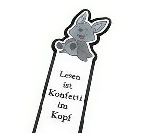 May include: A black and white bookmark with a cartoon bat illustration. The bookmark has the text "Lesen ist Konfetti im Kopf" on it.