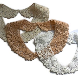 May include: Three lace collars in different colours: beige, light brown, and white. The collars are made of delicate lace with a floral pattern.