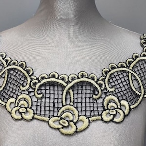 May include: Black lace trim with a delicate floral design in a light yellow colour. The trim is perfect for adding a touch of elegance to any project.