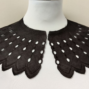 May include: Black lace collar with a scalloped edge and a delicate eyelet pattern.