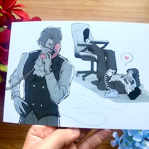 May include: Illustration of two men in suits, one standing and the other reclining, both using pink rotary phones. The standing man wears a vest and glasses. A heart icon floats above the reclining man. The artwork is in black and white.