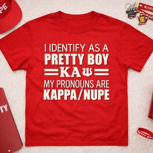 May include: Red t-shirt with the text "I IDENTIFY AS A PRETTY BOY =KA&Psi;= MY PRONOUNS ARE KAPPA/NUPE." Also, a red baseball cap, a red paddle with the word "PRETTY", a red tumbler, and other accessories.