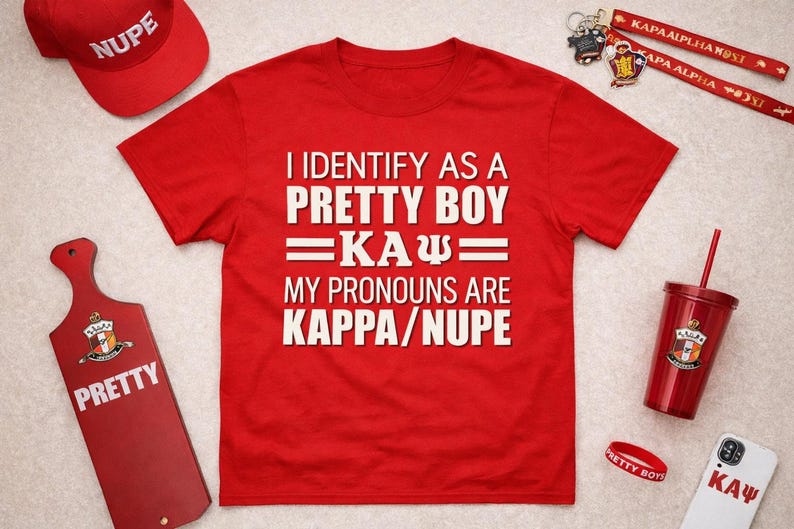 May include: Red t-shirt with the text "I IDENTIFY AS A PRETTY BOY =KA&Psi;= MY PRONOUNS ARE KAPPA/NUPE." Also, a red baseball cap, a red paddle with the word "PRETTY", a red tumbler, and other accessories.