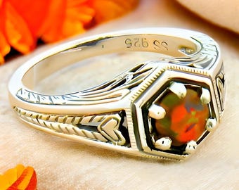 May include: A silver ring with an ornate design and a hexagonal red opal gemstone. The ring is marked "925" on the inside band.