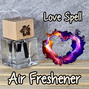May include: A clear glass bottle with a wooden lid and a black wick. The bottle is labeled "Love Spell Air Freshener" and features a heart-shaped image of flames.