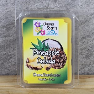 May include: A yellow wax melt with a pineapple and coconut design. The label reads "Ohana Scents" and "Pineapple Colada". The wax melt is 2.4 oz.