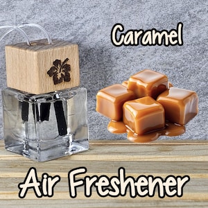 May include: A clear glass air freshener bottle with a wooden top featuring a carved flower design. The word "Caramel" is written above a pile of caramel candies. The words "Air Freshener" are written below the bottle.