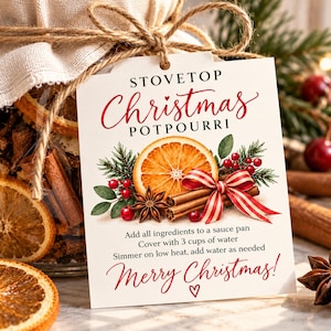 May include: A white rectangular tag tied to a jar with twine, featuring the text STOVETOP Christmas POTPOURRI, an illustration of an orange slice, cinnamon sticks, red berries, and a red-striped bow, with instructions to add 3 cups of water.