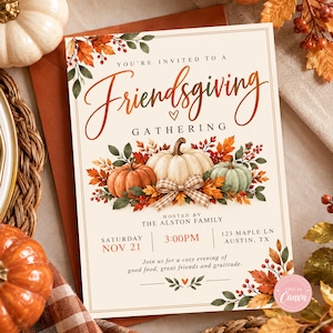 May include: A rectangular Friendsgiving invitation card featuring a cream background with orange and green autumn leaves, three pumpkins, and a plaid bow. Text includes: You're invited to a Friendsgiving gathering, hosted by The Alston Family, Saturday Nov 21, 3:00PM, 123 Maple Ln, Austin, TX, and Join us for a cozy evening of good food, great friends and gratitude.