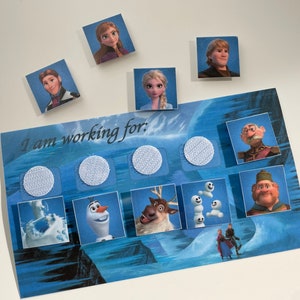May include: A blue and white game board with the text "I am working for:" and images of characters from the movie Frozen. The board has eight spaces with white circles in each space. There are eight small square cards with images of characters from the movie Frozen.