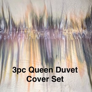 May include: A 3-piece queen-sized duvet cover set with a tie-dye pattern in shades of gray, purple, yellow, and orange.