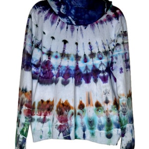 Pode incluir: Um moletom branco tie-dye com um padr&atilde;o azul, roxo e verde. O moletom tem capuz e mangas compridas.