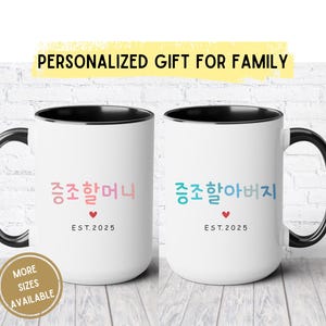 May include: Two white ceramic mugs with black handles and black rims. The mugs have the text "증조할머니 EST. 2025" and "증조할아버지 EST. 2025" printed on them in Korean and English.