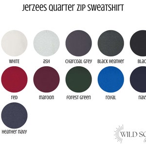 May include: Image showcasing a color chart for Jerzees quarter zip sweatshirts. Colors include white, ash, charcoal grey, black heather, black, red, maroon, forest green, royal, navy, and heather navy. The Wild Son Goods logo is in the bottom right corner.