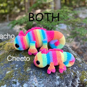 May include: Two crocheted rainbow chameleon plushies, one larger than the other, are sitting on a rock. The larger one is labeled "Nacho" and the smaller one is labeled "Cheeto". The text "BOTH" is above the plushies.