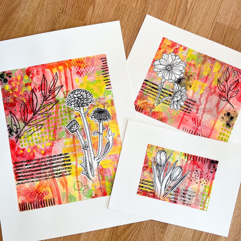 May include: Three art prints with red, yellow, and green backgrounds featuring black and white floral illustrations. The prints are mounted on white cardstock.