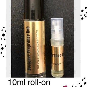 May include: Two bottles of fragrance oil, one is a 10 ml roll-on bottle and the other is a 2 ml spray bottle. Both bottles are gold with black lettering that says "Designer Fragrance Hub" and "Premium Fragrance Body Oil".