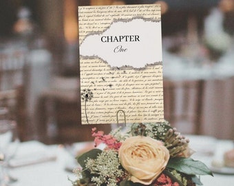 Puede incluir: Una tarjeta de número de mesa con un diseño vintage. La tarjeta está hecha de papel con un aspecto desgastado y presenta un gráfico de diente de león. El texto en la tarjeta dice "Capítulo Uno".