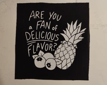 May include: Black and white embroidered patch with the text "Are you a fan of delicious flavor?" and a pineapple and blueberries.