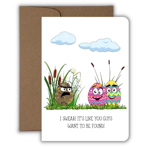 May include: A humorous Easter card featuring a camouflage egg with a grumpy face and two brightly colored eggs with happy faces. The text reads "I swear! It's like you guys want to be found!"