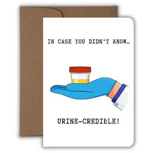 Pu&ograve; includere: Un biglietto d'auguri bianco con busta marrone che presenta un'illustrazione a cartone animato di una mano con guanto medico blu che tiene un piccolo contenitore per campioni con liquido giallo e tappo rosso. Il testo recita: IN CASE YOU DIDN'T KNOW... URINE-CREDIBLE!