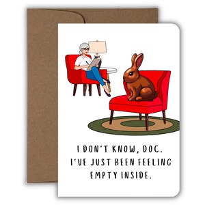 May include: A humorous greeting card with a cartoon illustration of a woman sitting in a red chair with a rabbit in another red chair. The text on the card reads "I don't know, doc. I've just been feeling empty inside."