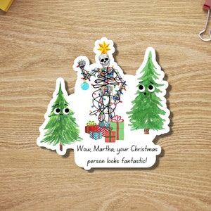 May include: A skeleton is tangled in Christmas lights and standing on top of a stack of wrapped presents. Two green Christmas trees with googly eyes look on. The text reads "Wow, Martha, your Christmas person looks fantastic!"