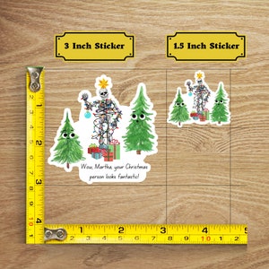 May include: Two sticker options for a funny Christmas-themed design featuring a skeleton dressed as a Christmas tree. The larger sticker is 3 inches and the smaller sticker is 1.5 inches. The text on the sticker reads "Wow, Martha, your Christmas person looks fantastic!"