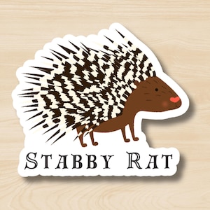 May include: A sticker featuring a cartoon porcupine with black and white quills and a brown body. The porcupine has a pink nose and is looking to the right. The text "STABBY RAT" is printed below the porcupine.