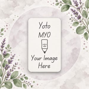 Peut inclure: Une carte rectangulaire blanche aux coins arrondis avec le texte noir Yoto MYO, une petite icône de crayon avec un visage souriant et le texte Your Image Here. La carte est centrée sur un fond circulaire avec de la lavande à l'aquarelle.