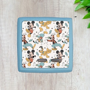 May include: A blue zippered pouch with a white background featuring a repeating pattern of Mickey Mouse, Donald Duck, and Pluto in various poses. The characters are in vintage cartoon style with red, yellow, and blue colors.
