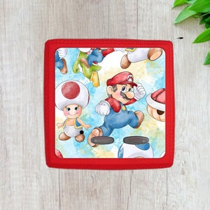 Peut inclure: Étui carré rouge avec un motif de dessin animé coloré représentant Mario, Luigi et Toad. Le motif est de style aquarelle avec un fond bleu, jaune et blanc.