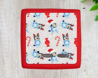 Könnte beinhalten: Eine quadratische Fliese in Rot und Weiß mit Weihnachtsmotiven. Es ist ein sich wiederholendes Muster aus blauen und weißen Cartoon-Hunden zu sehen, die Weihnachtsmützen und Rentiergeweihe tragen. Die Fliese hat einen roten Rand.