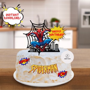 Pode incluir: Um bolo branco decorado com um topo de bolo do Homem-Aranha. O topo apresenta o Homem-Aranha balançando em uma teia de aranha, com uma cidade ao fundo. O bolo também tem balões de fala de estilo de quadrinhos vermelho, amarelo e azul com as palavras "Kapow!" "Spiderman" e "Pow!" O bolo é decorado com um balão de fala amarelo e vermelho "Feliz Aniversário".