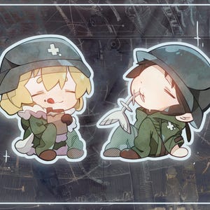 Llaveros holográficos destrozados de Yuuri y Chito de Girls Last Tour