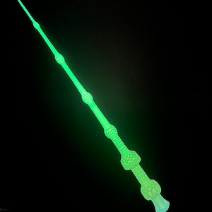 Op de afbeelding: Een groene glow-in-the-dark toverstaf met een getextureerd oppervlak.