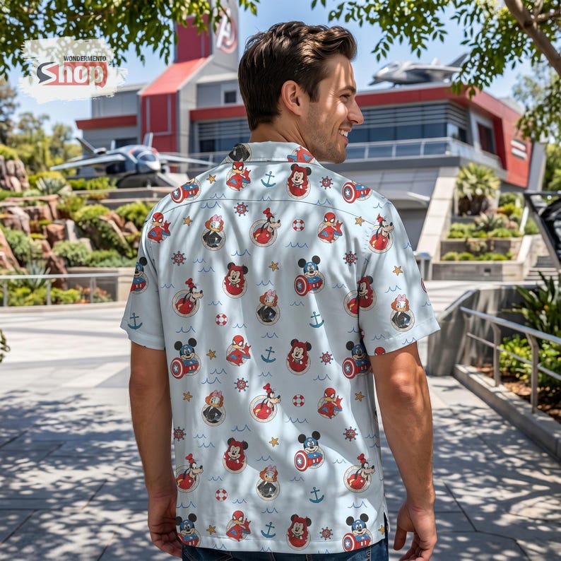 May include: A light blue short-sleeve button-down shirt featuring an all-over print of Disney characters including Mickey Mouse, Minnie Mouse, Goofy, and Spider-Man, interspersed with nautical icons like anchors, ship wheels, and life preservers.
